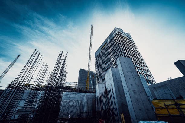 Institutional building under construction with structural rebar in the foreground